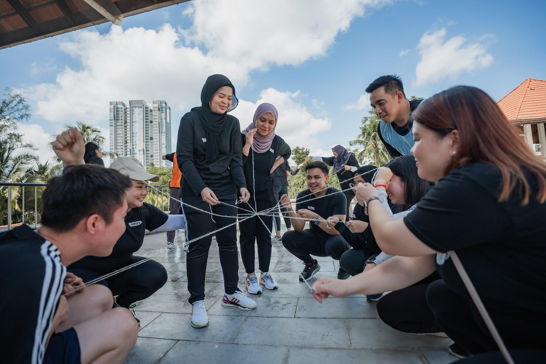 Outdoor team building challenge with ropes during an AZEO group session in Malaysia
