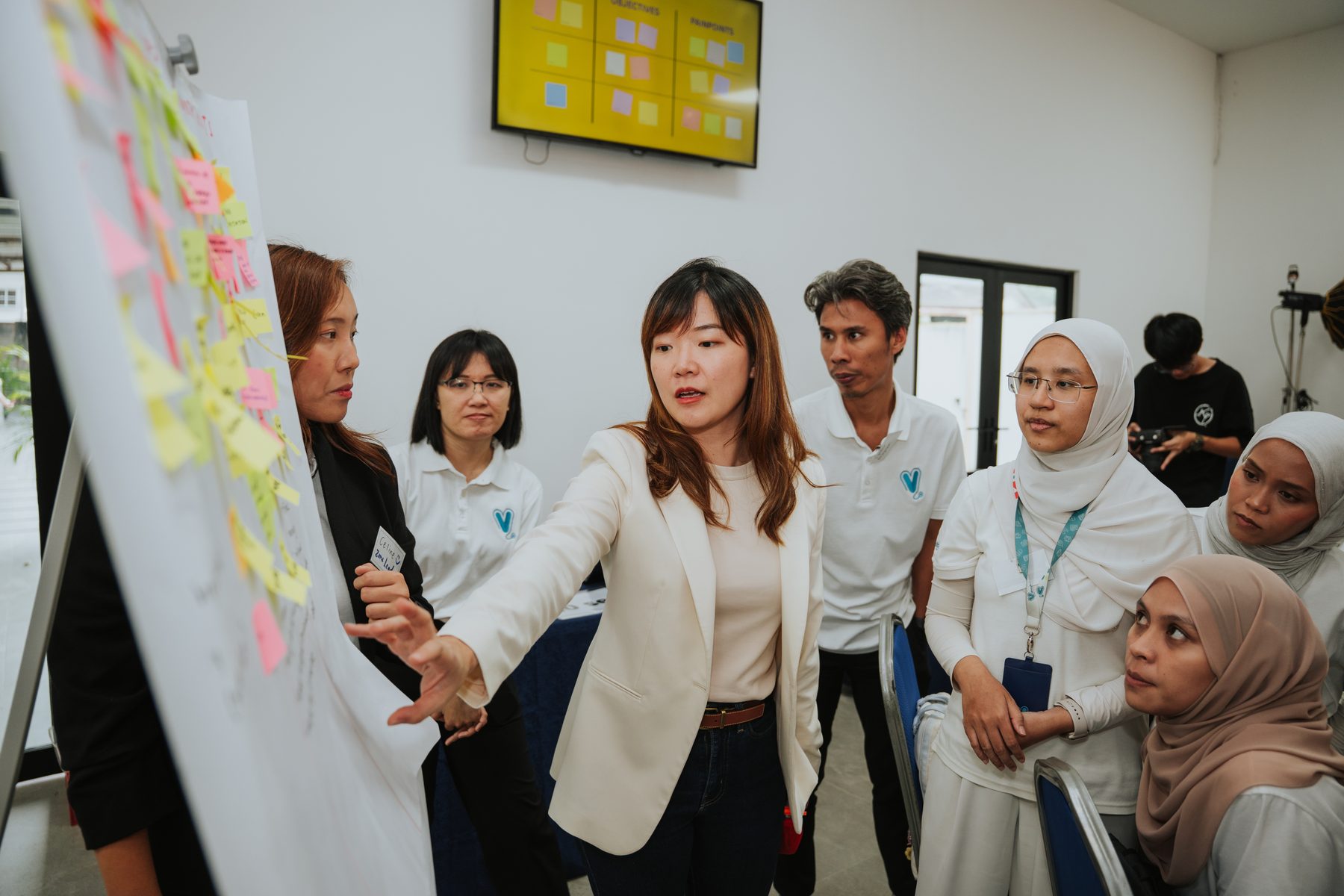 A participant presenting at a flipchart during an AZEO workshop